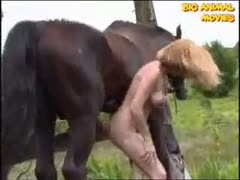 A mature, workaholic woman enjoying a horse knob outside
